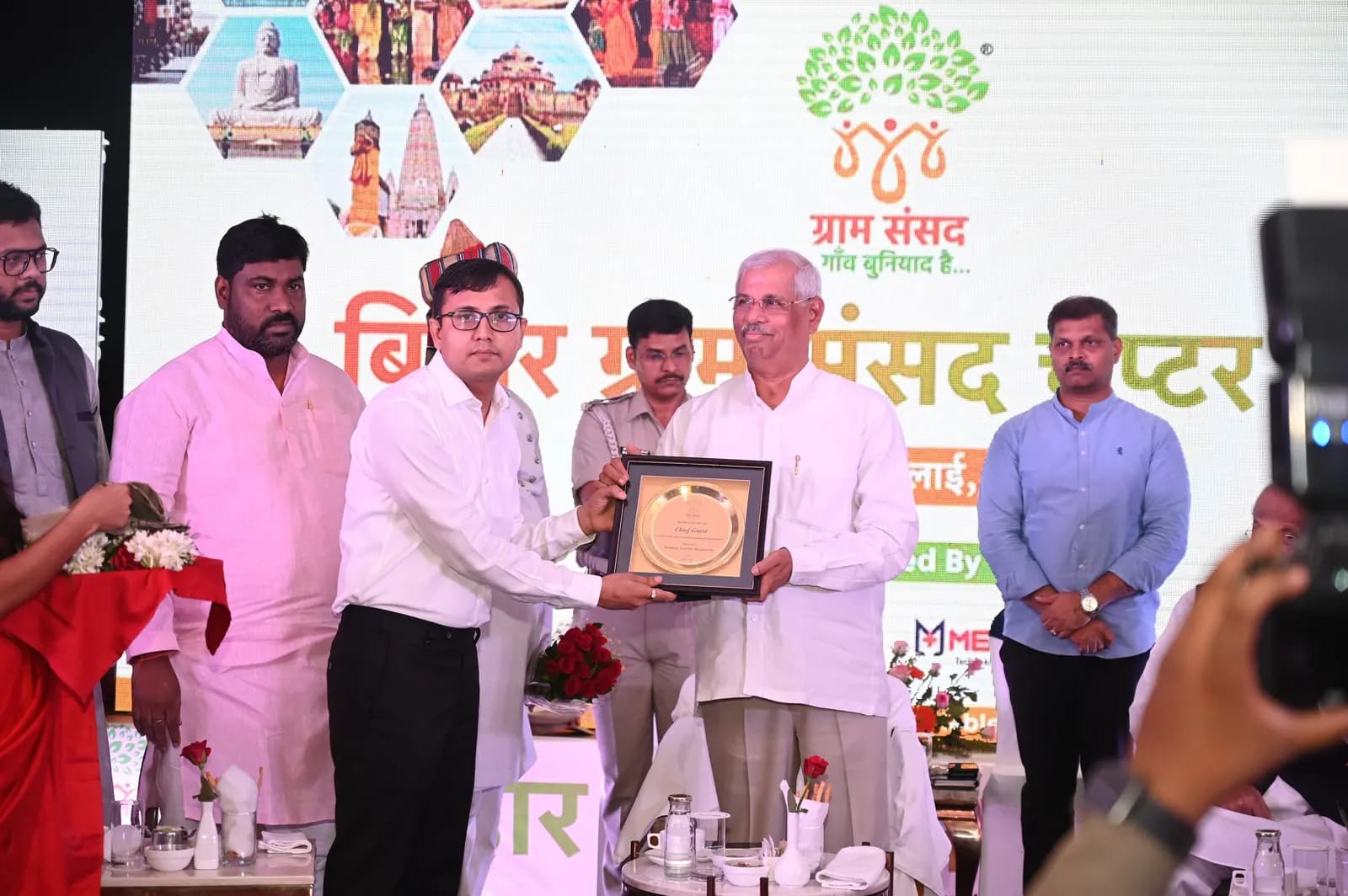 Presenting a plaque to a dignitary at the Bihar Chapter